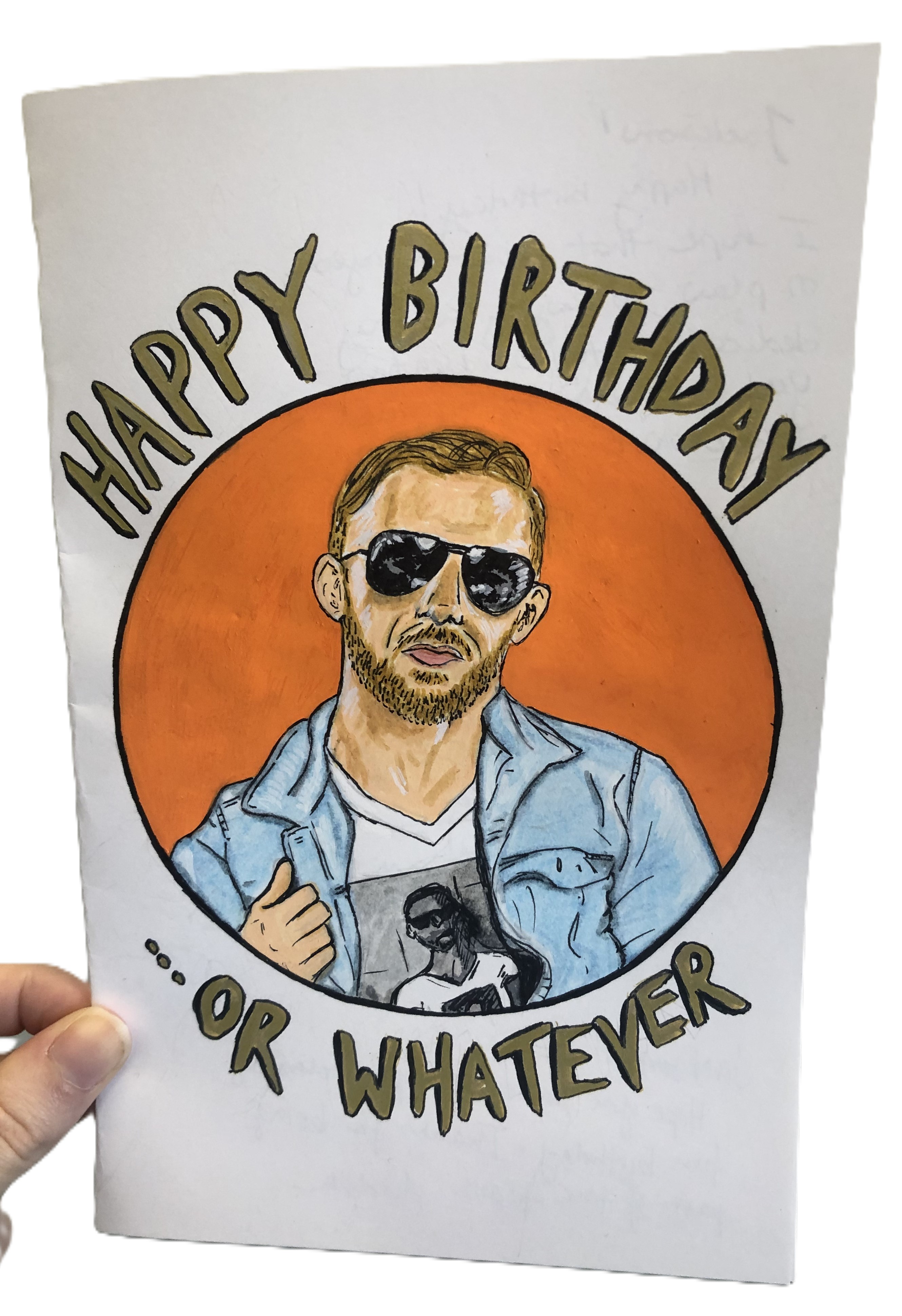 A birthday card I made for a co-worker with a drawing of the wrestler Orange Cassidy giving a lazy thumbs up with the words Happy Birthday... or whatever; I created the card with acrylic markers and ink.