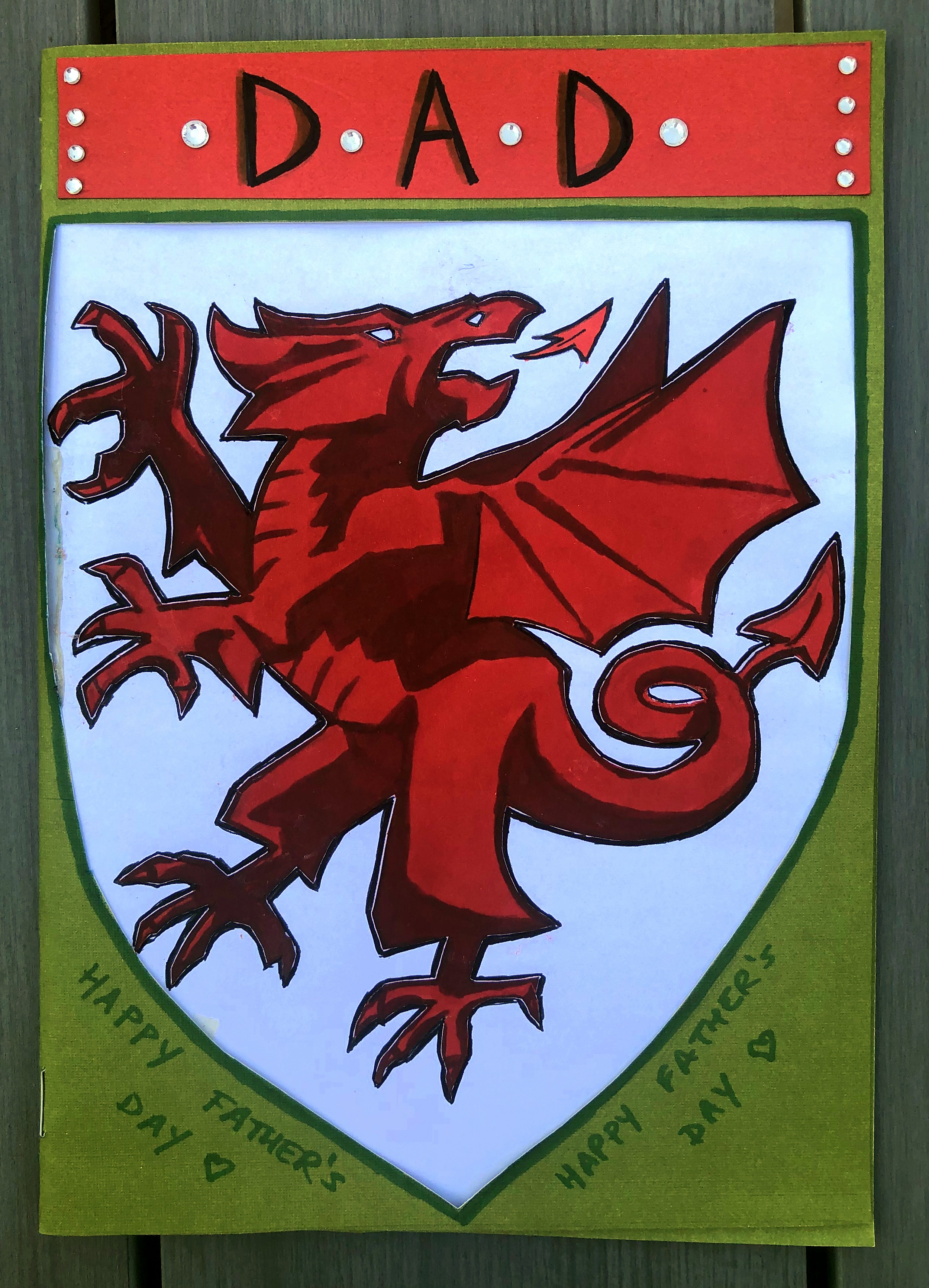 A card I made for father's day with the Welsh football team's logo on it. He sadly passed away 3 days later. I created the card with ink, colored paper, and stickers.