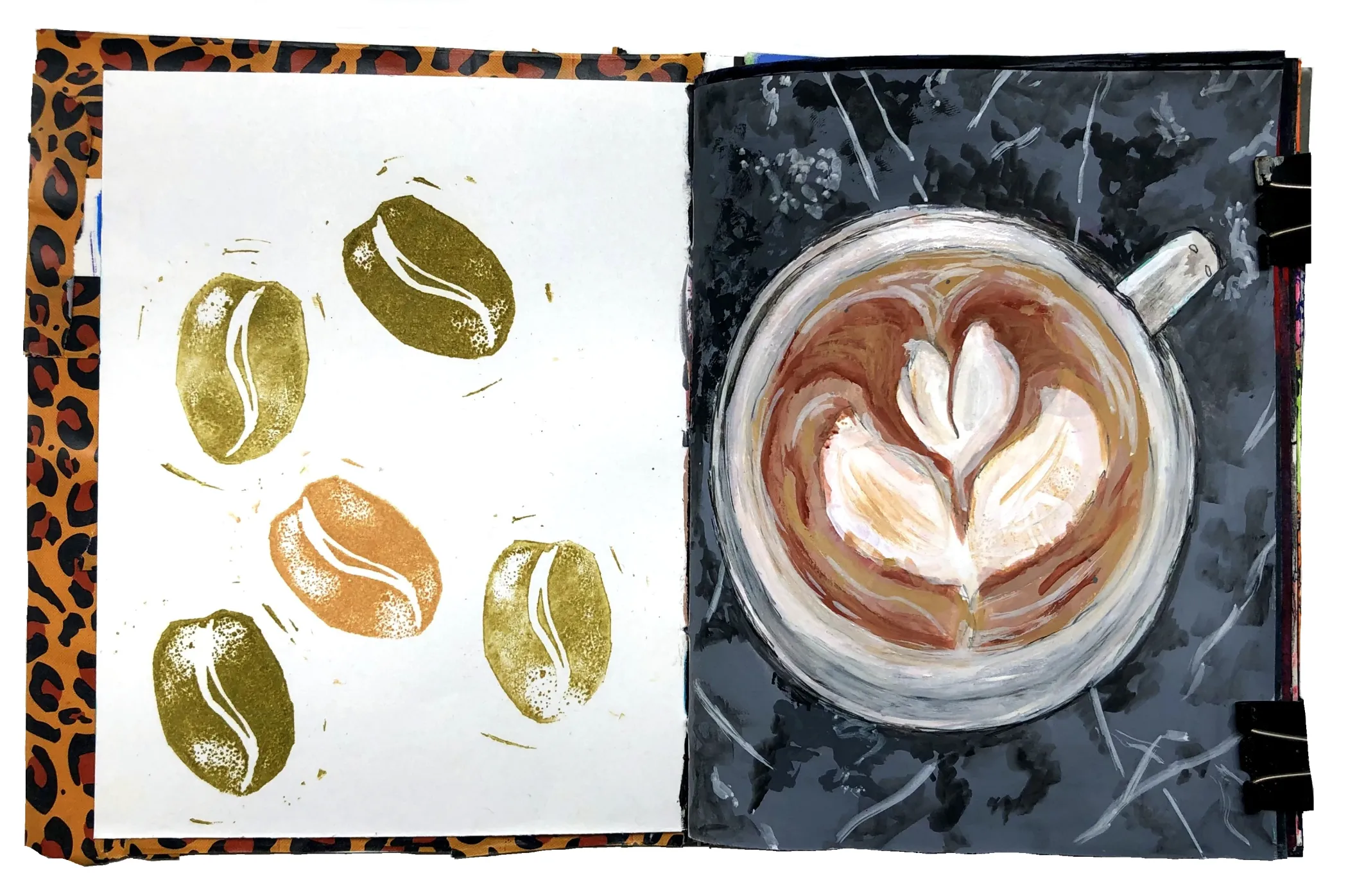 A mixed media art journal lino print of coffee beans and a painting of a coffee with a tulip design.