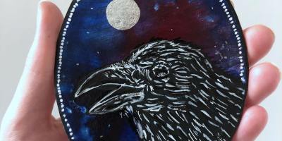 Coaster art of a crow and a full moon; it was created with ink and acrylic paint.